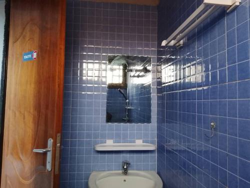Baño de azulejos azules con aseo y espejo en Guibi, en Ouagadougou