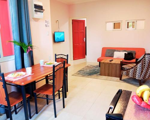 una sala de estar con una mesa y un sofá en Dolfijn Studios, en Paramaribo