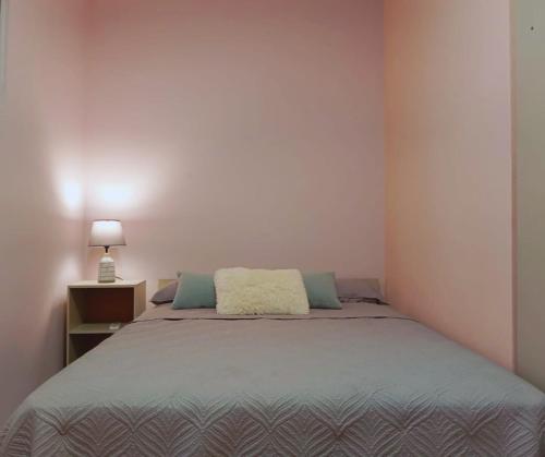 Un dormitorio con una cama y una lámpara sobre una mesa. en Dolfijn Studios, en Paramaribo