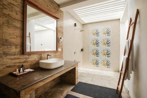 a bathroom with a sink and a mirror at Hibiscus Beach Hotel & Villas in Kalutara