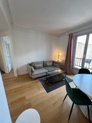 un salon avec un canapé et une table dans l'établissement Beautiful Flat Paris Monceau Champs Élysée, à Paris
