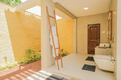 a bathroom with a toilet and a ladder in it at Hibiscus Beach Hotel & Villas in Kalutara