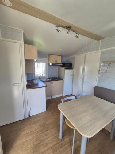 - une cuisine avec une table, une table et des chaises dans l'établissement camping la plage de l'orb, à Cessenon