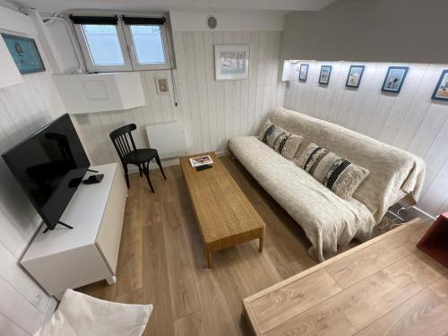 a living room with a couch and a table at La maison des écoliers in Deauville