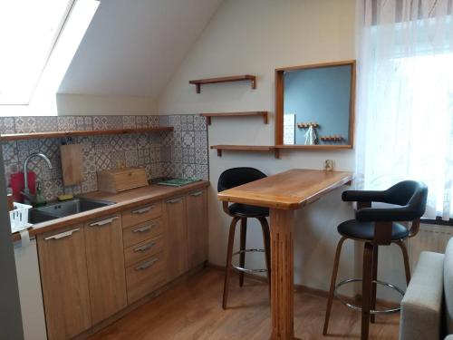 a kitchen with a wooden table and two bar stools at Olivia in Sianozety