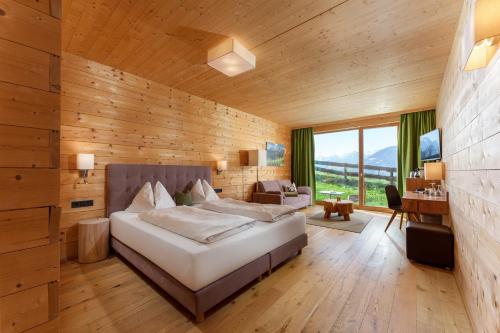a bedroom with a large bed in a wooden wall at Rittis Alpin Chalets Dachstein in Ramsau am Dachstein
