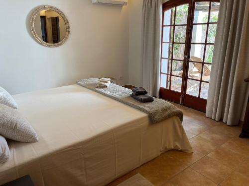 a bedroom with a bed with a mirror and a window at Casa Anexo in San Antonio