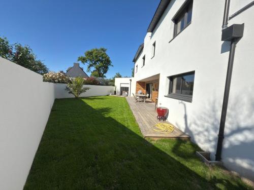 a backyard of a white house with a lawn at La Parenthèse du golfe chambre d hôte in Arradon