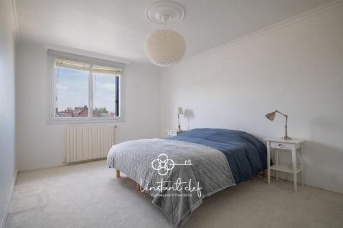 une chambre blanche avec un lit et une fenêtre dans l'établissement Charme au Mans - Jardin arboré & douceur de vivre, au Mans