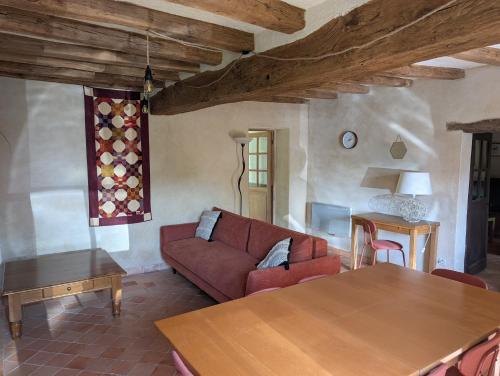 un salon avec un canapé rouge et une table dans l'établissement Maison de campagne avec piscine privée, à Le Guédéniau