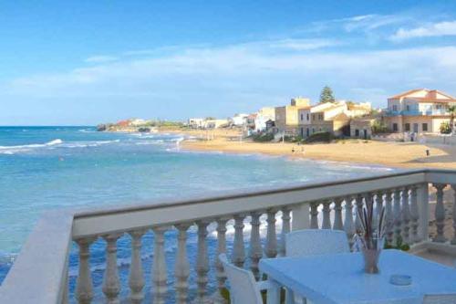 einen Balkon mit einem Tisch und Strandblick in der Unterkunft Casa Vacanza Mare Blu in Villaggio Azzurro