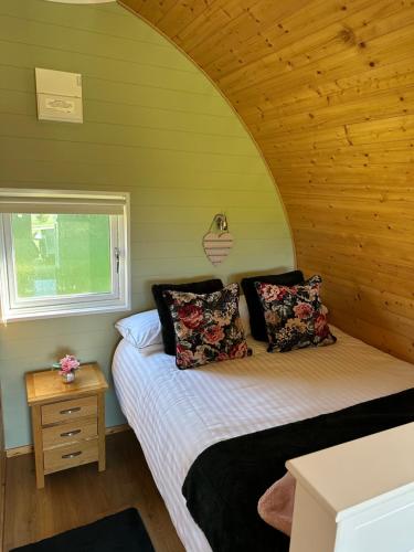 a bedroom with a bed in a room with a window at Southwell Retreat Glamping Pods in Southwell