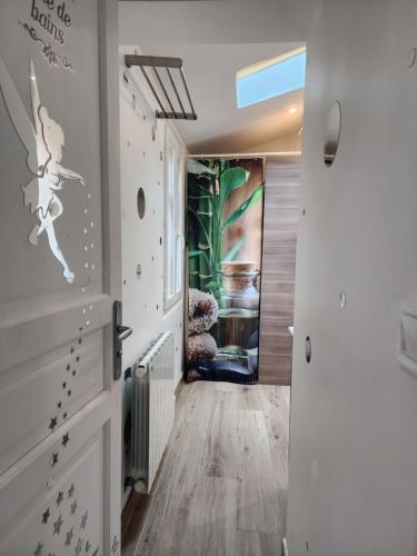 une pièce avec un couloir avec un mur avec des dessins dessus dans l'établissement Maison entouré par un jardin proche Paris et Disney, à Pontault-Combault