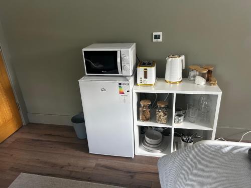 a microwave sitting on top of a white refrigerator at Maggies Cottage in Belturbet