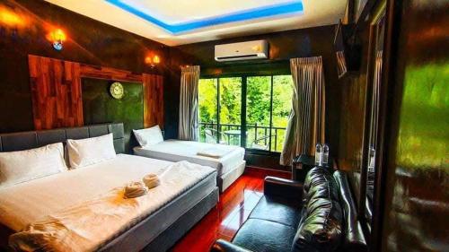 a bedroom with a large bed and a balcony at นาธาริเวอร์ไซด์ in Ban Lamphu La (3)