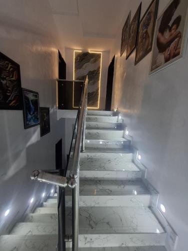 a stairway with lights and paintings on the wall at White House Villa Ogombo in Sangotedo