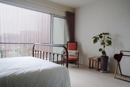 a bedroom with a bed and a large window at Chulin Homestay in Tainan