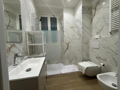 a white bathroom with a sink and a toilet at Bella Como Holiday Apartment in Como