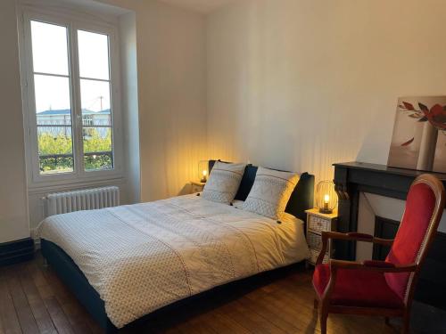 - une chambre avec un lit, une cheminée et une chaise dans l'établissement Grand appartement avec terrasse - A 5 min de la Cathédrale, à Bourges