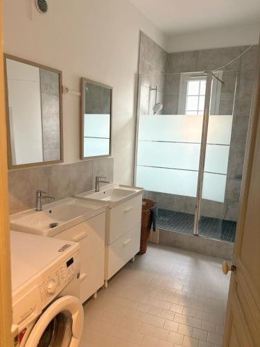 une salle de bain avec deux lavabos et une douche dans l'établissement Grand appartement avec terrasse - A 5 min de la Cathédrale, à Bourges
