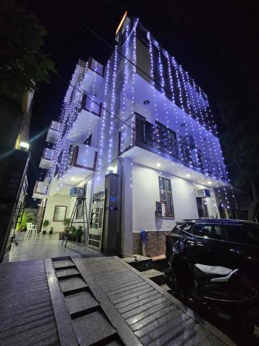 a building with lights on it with a car parked in front at Shri Krishna Divine Dham in Mathura