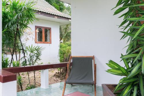 a chair on the balcony of a house at Chiltern cottages in Amphoe Koh Samui