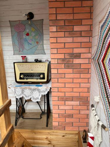 a kitchen with a brick wall and a table with a toaster at Ozierański Eden "Pod rzeźbami" in Krynki