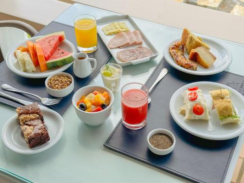 a table with plates of food on a table at Hotel Recanto do Atalaia in Arraial do Cabo