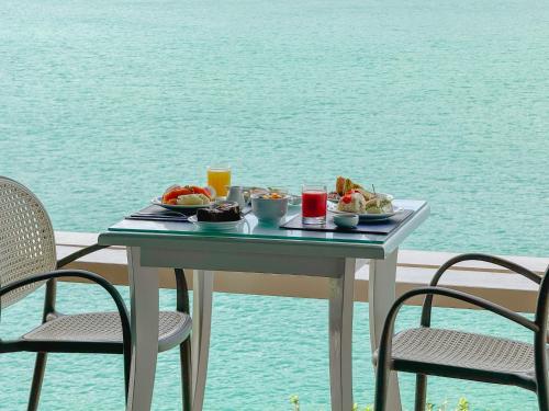a table with a tray of food on top of the water at Hotel Recanto do Atalaia in Arraial do Cabo