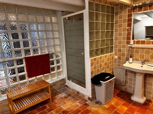 La salle de bains est pourvue d'un lavabo, d'une douche et d'un banc. dans l'établissement Le loft Rognes nouvel hébergement, à Rognes