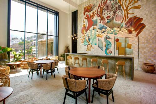 a restaurant with tables and chairs and a mural at Zona romantica cerca del muelle los muertos in Puerto Vallarta