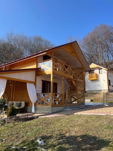 a large wooden house with a gambrel roof at Карпатська Модрина in Kosiv