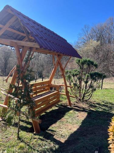 a wooden gazebo with a roof in a field at Карпатська Модрина in Kosiv