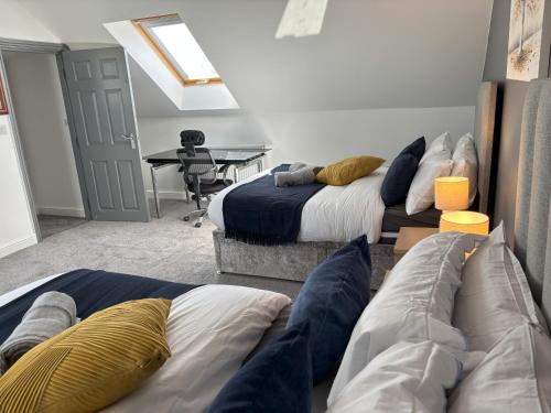 a room with two beds and a desk with a table at Sunderland City Delight free parking in Sunderland