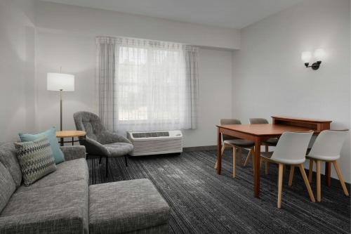 a living room with a couch and a table and chairs at TownePlace Suites Suffolk Chesapeake in Suffolk