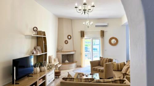 a living room with a couch and a tv at Oasis Centrale in Panteli