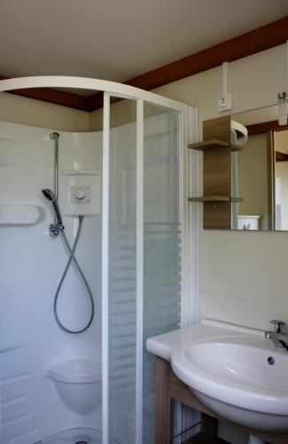 une salle de bain blanche avec une douche et un lavabo dans l'établissement Les Hauts de Torraccia, à Cargèse