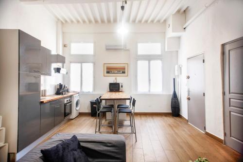 une cuisine avec une table et des chaises dans une pièce dans l'établissement Grand appartement, plein centre, à La Ciotat