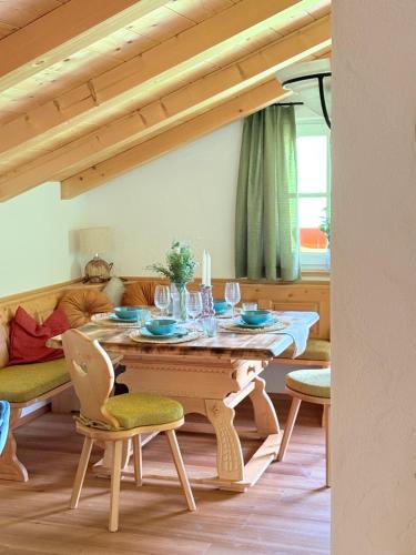a dining room with a wooden table and chairs at Ferienwohnung Datzmannlehen mit traumhaften Bergblick und Sauna in Ramsau