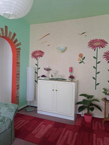 a living room with flowers on the wall at Pension Kaufmann Ferienwohnung "Wolke 7" in Oberwiesenthal