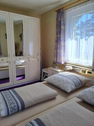 two beds sitting in a room with a window at Pension Kaufmann Ferienwohnung "Wolke 7" in Oberwiesenthal