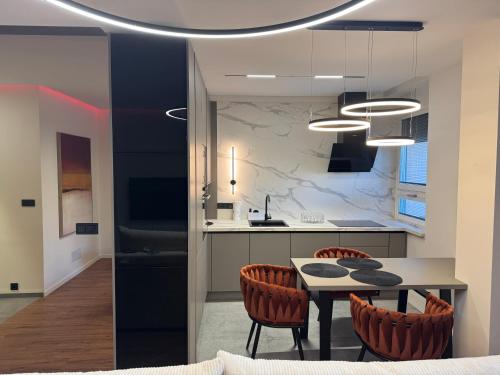 帕尔杜比采Moderní Hi-Tech apartmán v centru Pardubic - Wi-Fi, Netflix, projektor的配有桌椅的厨房和餐厅