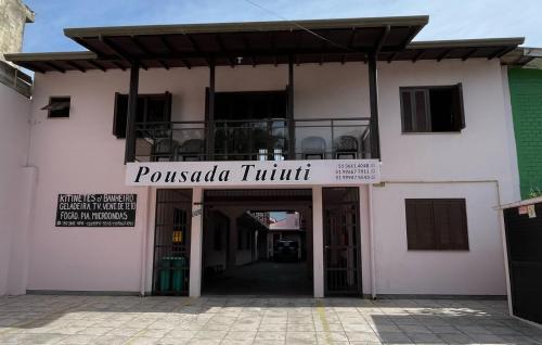 a building with a sign that reads pueblo truth at Pousada Tuiuti in Tramandaí