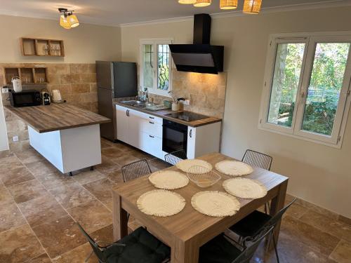 Il comprend une cuisine avec une table en bois et un comptoir. dans l'établissement Maison de charme avec jacuzzi, vue sur Gordes à 5mn du centre du village, à Gordes