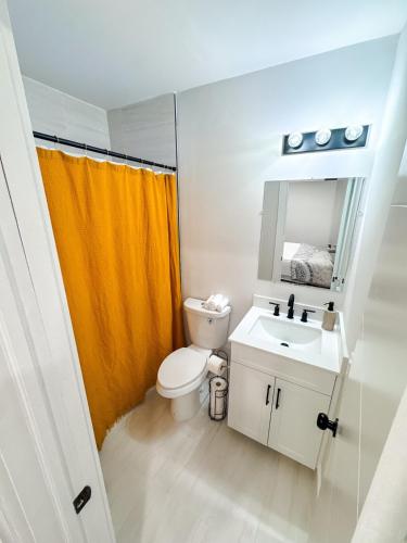 a bathroom with a toilet and a sink and a mirror at Miami Freedom Park Oasis by H&S in Miami