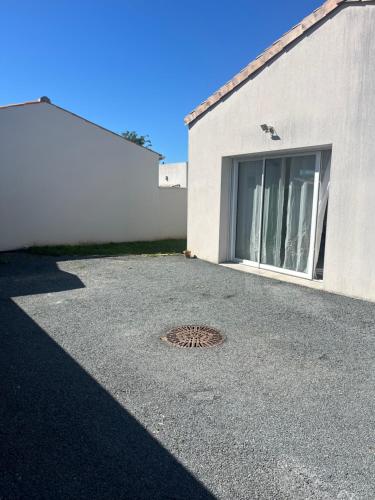 une plaque d'égout devant un bâtiment dans l'établissement LIL de SAND, à Bourcefranc