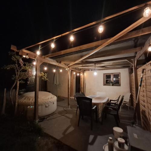 a patio with a table and a tub at night at Gîte Coume a Case, Pyrénées Atlantiques in Lys
