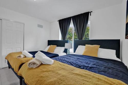 Un dormitorio con dos camas con toallas encima. en Central Stunning Villa with Heated Pool Cabana, en Hollywood Ridge Farms