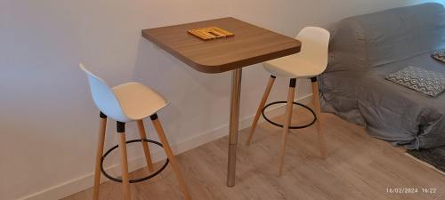 une table et deux chaises à côté d'un lit dans l'établissement Studio Cosy centre Toulouse, à Toulouse