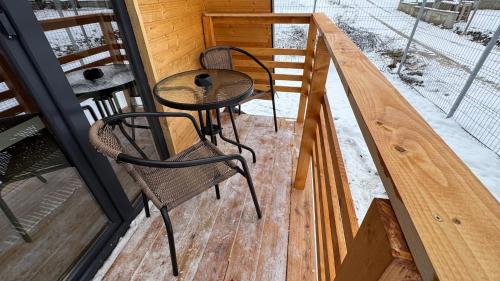 a patio with two chairs and a table on a porch at Cabana Luminis in Râşnov